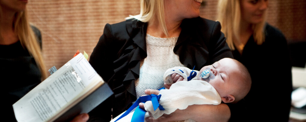 Tre kvinder samlet i en kirke. Den midterste holder et barn.